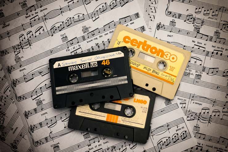 three cassette tapes laying on several pages of sheet music spread across the background. the music is Send in the Clowns